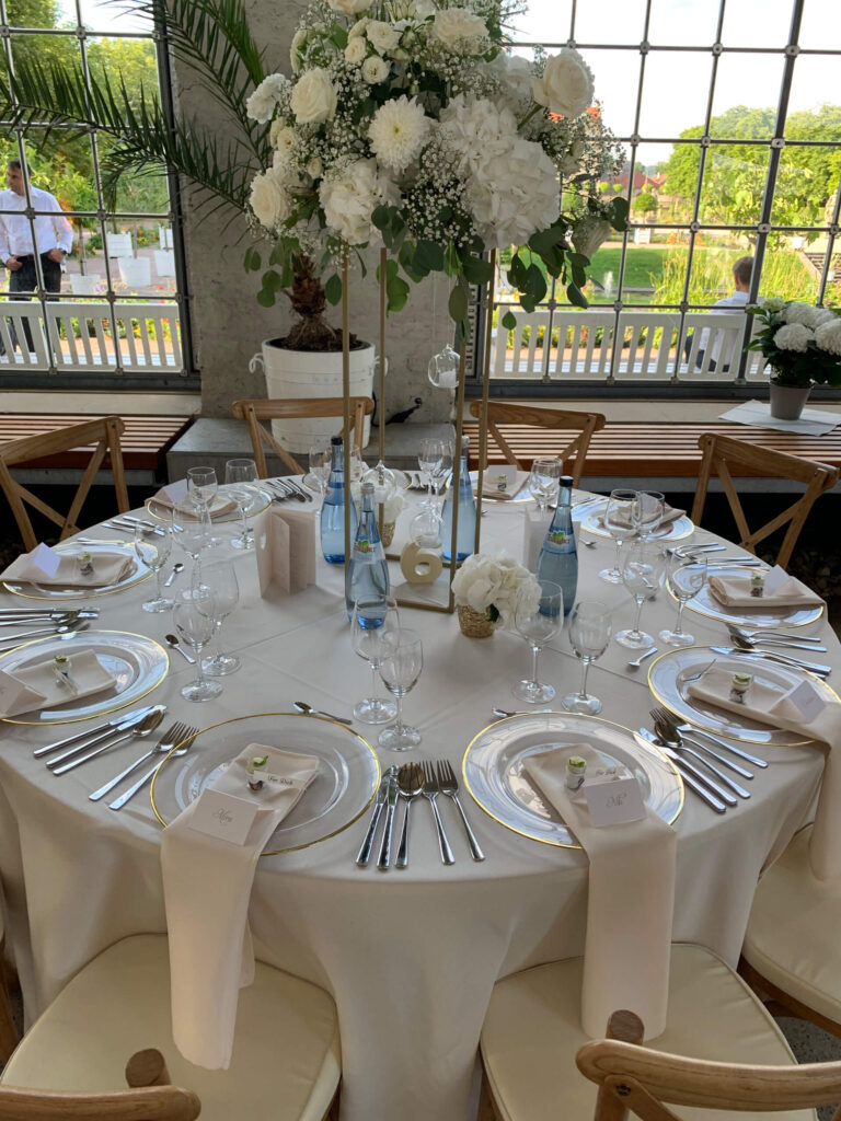 Gedekter Tisch mit weißer Tischdecke und Blumen auf einer Hochzeit in Weikersheim